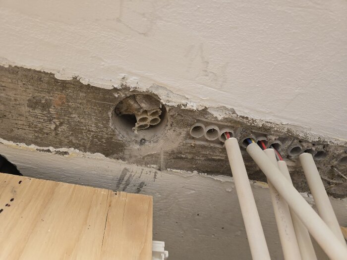 Oanvända vp-rör i ett bjälklag som planeras att bytas mot flexrör, synliga elkablar framträder.