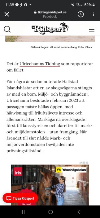 En kvinna står bredvid en häst i en stallgång, där stallboxarna syns i bakgrunden.