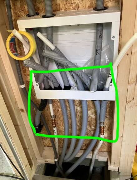 Skåpinstallation med flera rör anslutna, markerad med grön rektangel. Diskuteras placering av skarv och skvallerrör enligt regelverk.