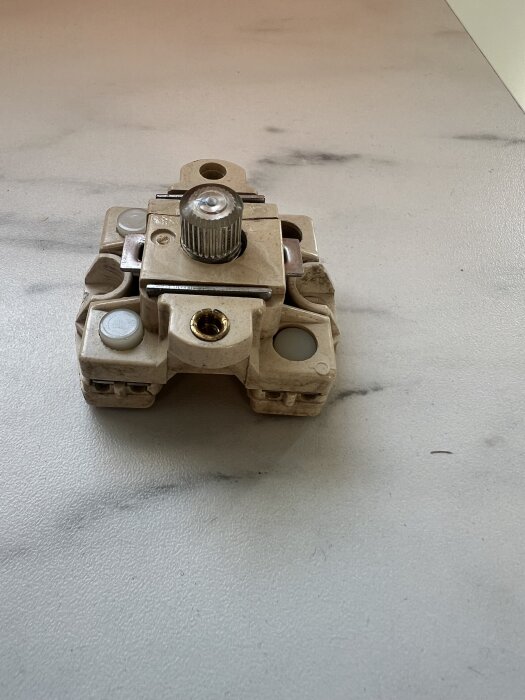 Gamla keramiska proppsäkring på ett marmorerat underlag.