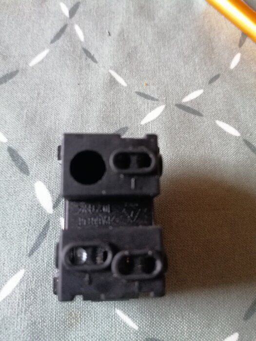 Närbild på en strömbrytare med märkningar, inklusive ett L och pilar, där användaren undrar var kablarna ska monteras.