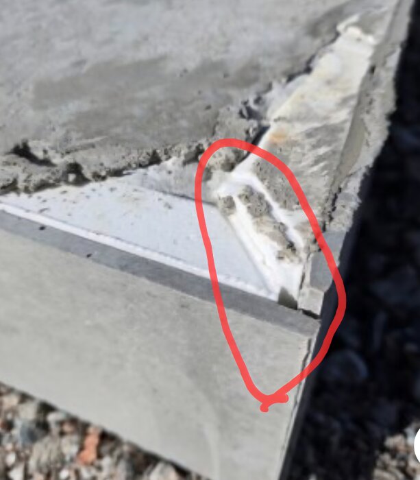 Betongyta med ojämna nivåer markerade med röd cirkel, visar diskrepans i byggarbetet.