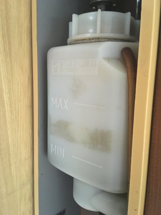 Plastkärl för kylvätska i en husvagn, märkt med max och min-nivåer. Kärlet verkar behöva påfyllning enligt användarens observationer.