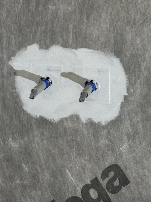 Två rörgenomföringar i en vägg med tätning och isolering, märkta med texten "tea".