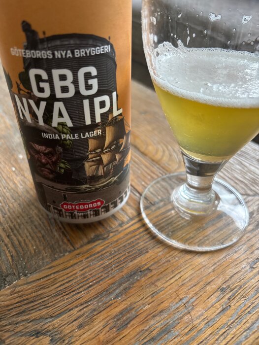 En flaska och ett glas med Göteborgs Nya Bryggeri GBG Nya IPL, en India Pale Lager, på ett bord.