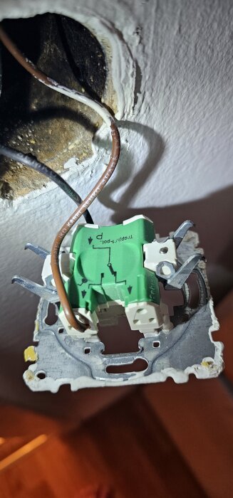 Gamla elinstallationen på en vägg, med grönt kopplingsdon och anslutna bruna kablar.