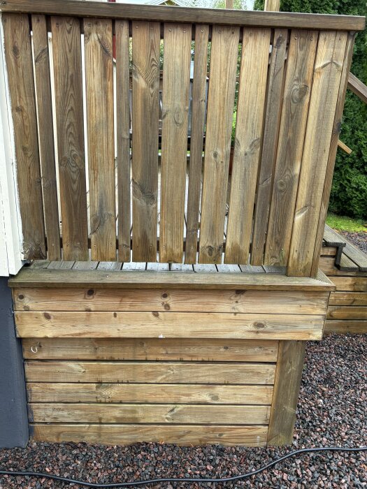 Träpanel utomhus i dagsljus som visar den ursprungliga färgen, med torr och väderbiten yta.