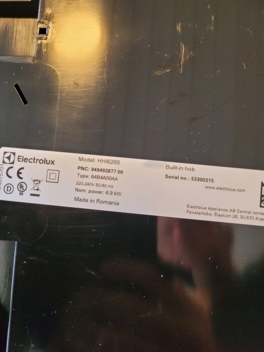 Etikett på en Electrolux inbyggnadshäll med tekniska specifikationer och fyrkantsymbol synlig.