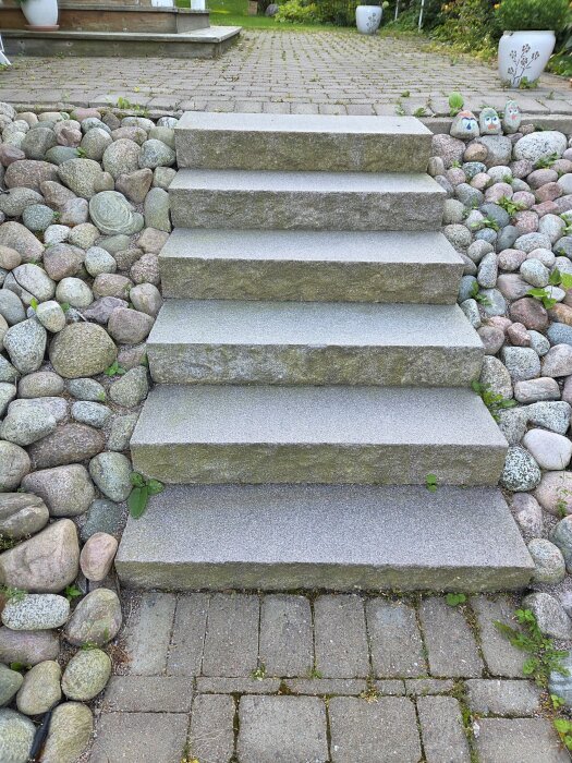 Trappa av granitblock med omgivande stenar, perfekt för montering av metallräcke.