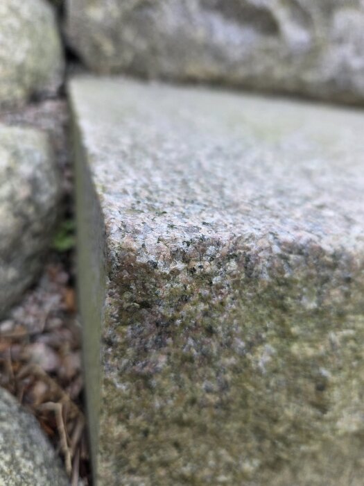 Närbild av en grov yta på ett granitblock, vilket ska användas för att montera ett metallräcke med kemisk förankring.