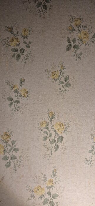Blommig tapet med gula rosor och gröna blad på en beige bakgrund.