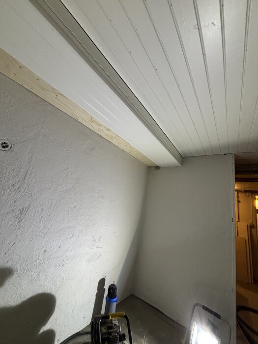 Trätak med pärlspont och ljus flödande ner på ett hörn av ett rum, där ytterligare bräder behövs för att avsluta projektet.