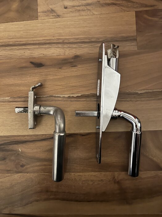 Gamla och nya spanjoretthandtag framför träyta, med tydlig skillnad i storlek på roddarpinnarna.