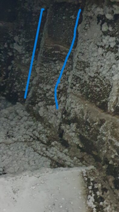 Spricka i skorstenens kanal markerad med blå linjer, omgiven av sot och stendamm.