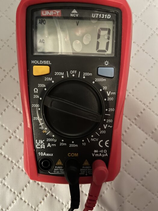 Multimeter från Jula inställd för att mäta 230 V växelström, med röd och svart kabel.