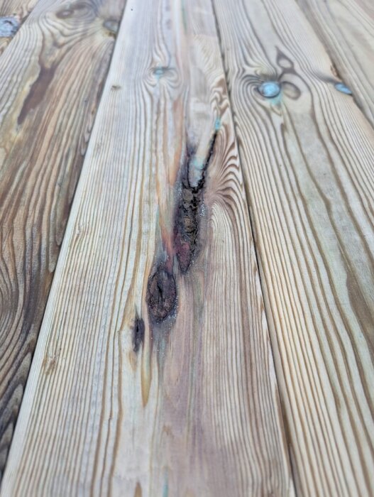 Bräda med spricka och missfärgning i fokus, del av premiumtrall G4-2 med kvalitetsproblem.