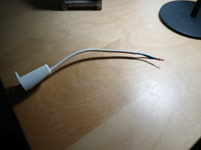 Lös elkabel med blå och koppartråd på träbord.