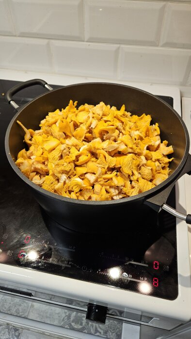Stekpanna fylld med kantareller på en spis.