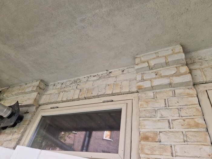 Fönster med tegelvägg ovanför, byggnad från 1927. Fråga om överliggare finns över fönstret eller om det vilar på fönsterkarmen.