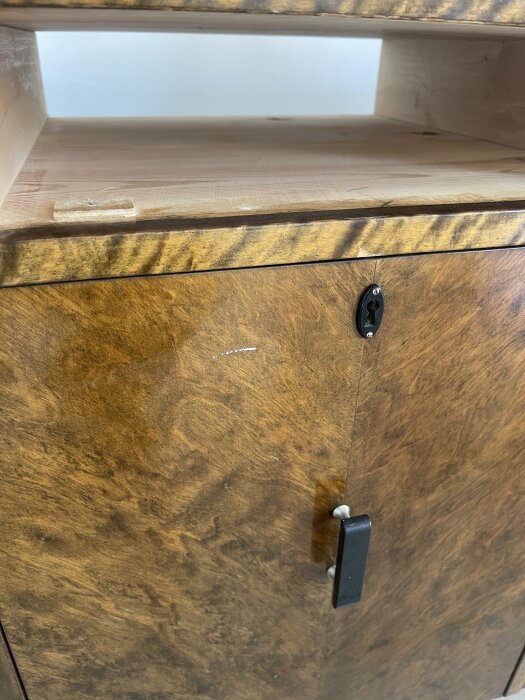 Byrå i bonad björk från 1940-talet med en liten vit färgfläck på framsidan, nära nyckelhålet.