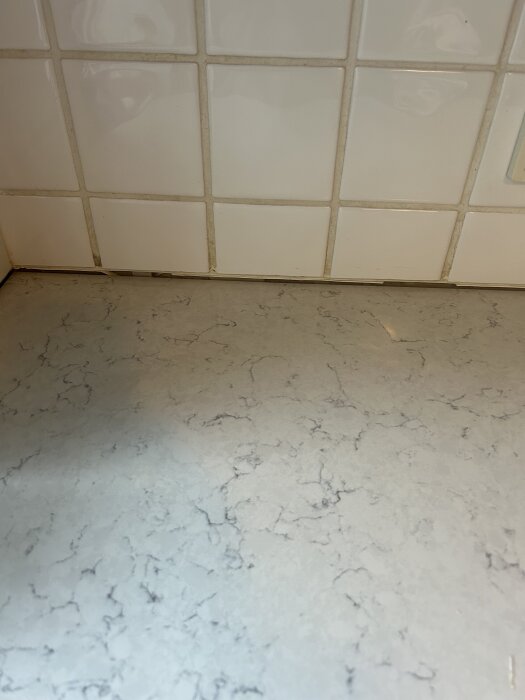 Glipa mellan bänkskiva och vitkaklad köksvägg som behöver tätas med fog eller silikon.