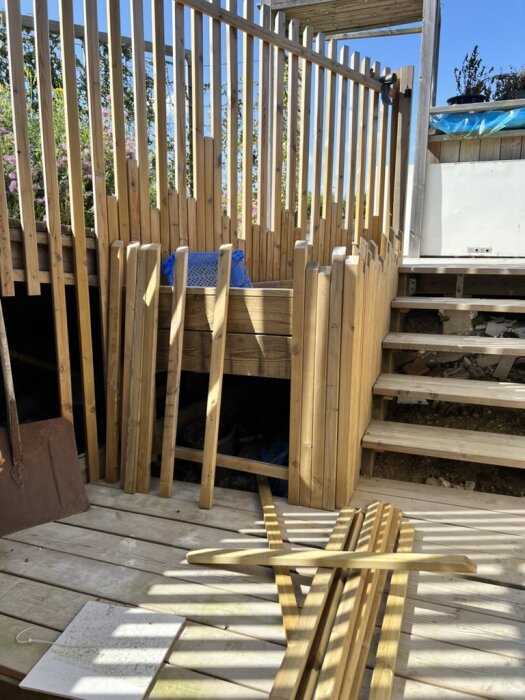 Nytillverkat staket vid en källartrappa med träräcke och liggande brädor, omgärdat av somrigt väder och färdigställd exteriör.