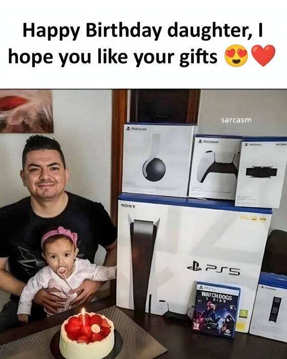 En man och en bebis firar födelsedag med en tårta, PS5, spel och tillbehör i bakgrunden.