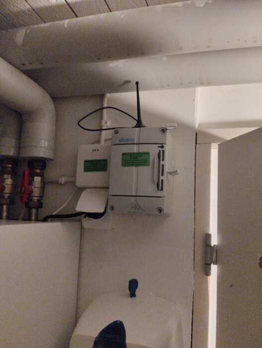 Elinstallationsbox och rör i ett äldre hus, del av ett pågående elrenoveringsprojekt relaterat till fjärrvärme.