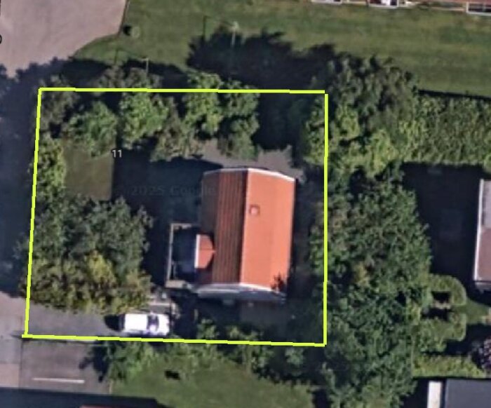 Luftfoto av ett hus med rödorange tak på Hisingen, Göteborg, omgivet av träd och en stor gräsyta markerad med gul linje.