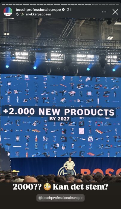 Stor skärm visar "+2000 nya produkter till 2027" med verktyg, person på scen framför stor publik.