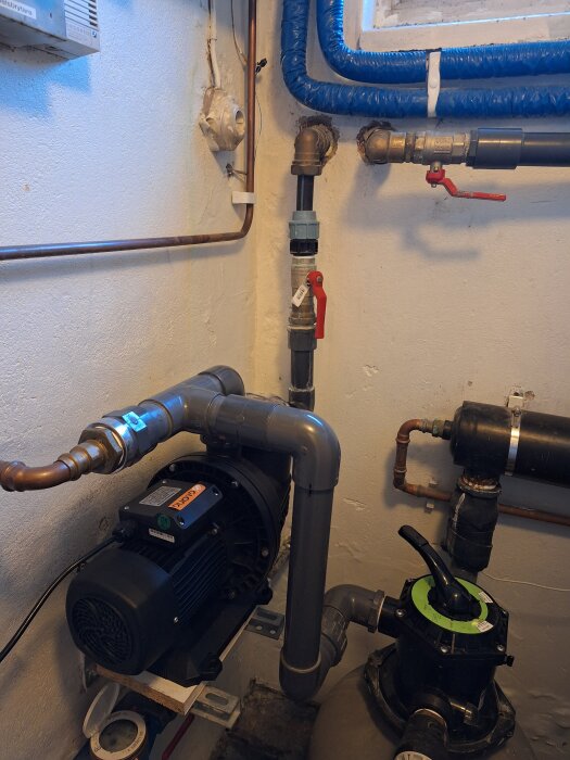 Poolpumpinstallation med rör, ventiler och kopplingar i ett teknikutrymme.