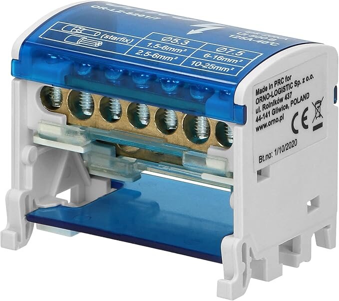 Elektriskt kopplingsblock med flera terminaler och en blå transparent skyddskåpa, används för att ansluta elektriska kablar i en elcentral.