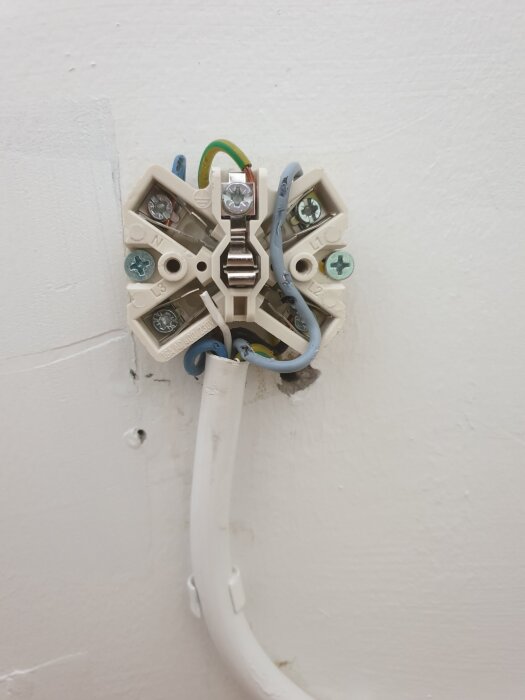 Spisuttag med exponerade ledningar kopplade av elektriker; dåligt utfört, orsakar att huvudsäkringen löser ut när spisen ansluts.