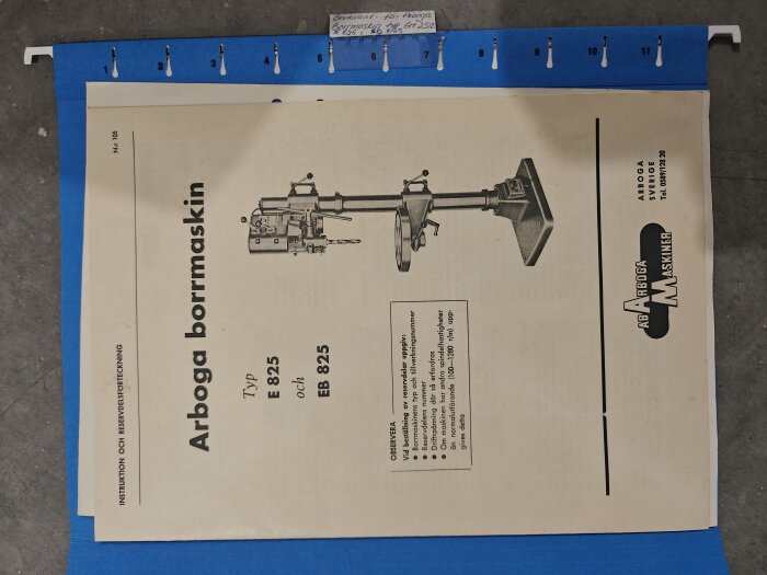 Manual för Arboga borrmaskin E 825 och EB 825, visas på blå bakgrund, med instruktioner och illustration av maskinen.
