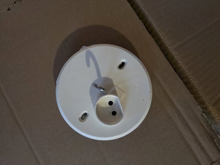 Ojordat lamputtag placerat på en kartong.