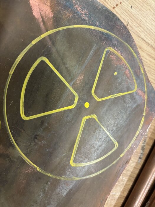 Gul markeringsmall på kopparplåt för bastuventil, uppmärkt för bearbetning.