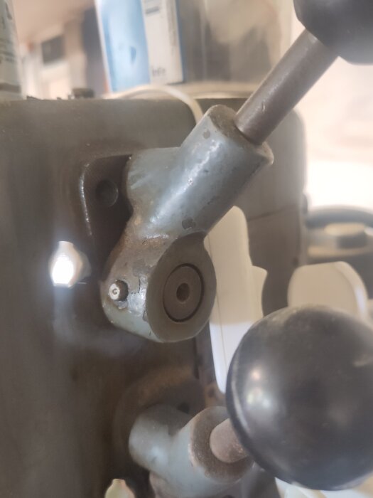 Närbild av en pelarborrs låsmekanism med fjäderbelastad kula, använd för att säkerställa olika lägen.