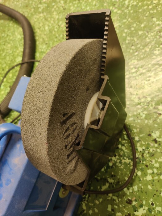 Begagnad bänkslip med en stor slipsten, saknar vettigt anhåll för stöd vid användning.