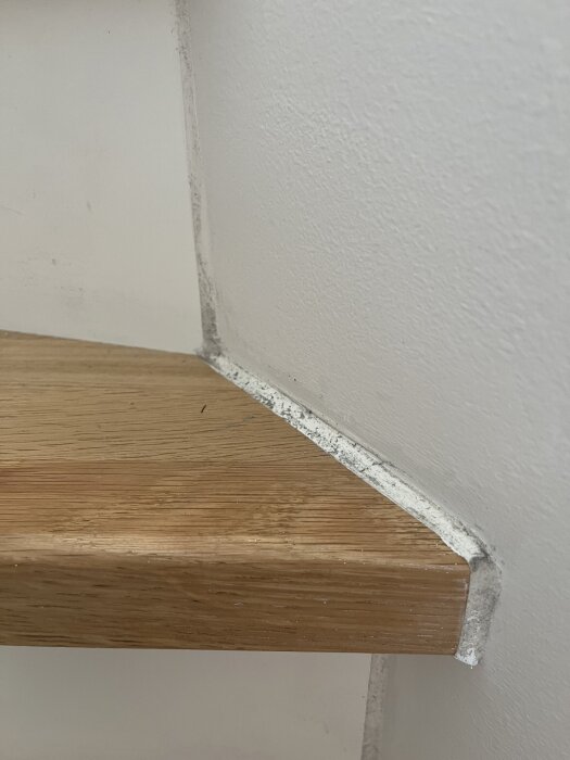 Närbild av en trappa med en trätrappsteg och fog som är täckt av damm längs kanten.