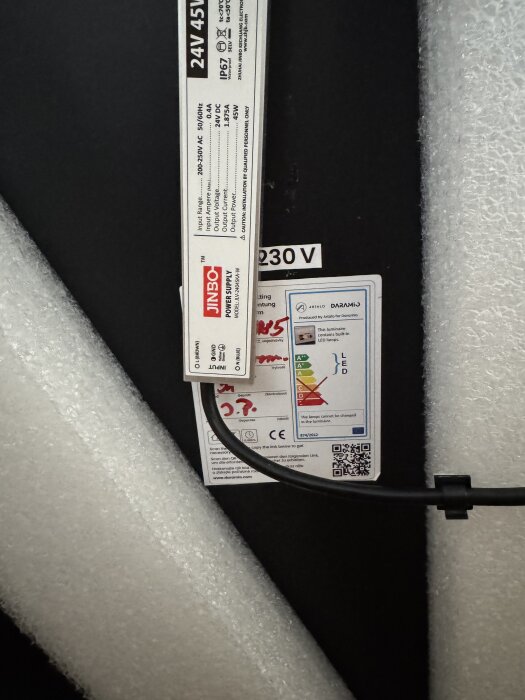 Etiketter och märkningar på elektrisk komponent för spegel, inklusive 24V 45W och energiklassning.