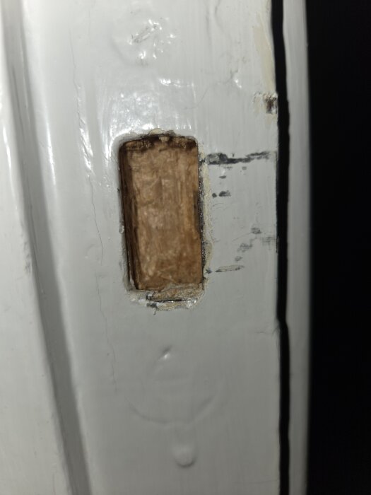 Närbild av en dörrkarm med urgröpning för att justera dörrstängningen på en äldre innerdörr.