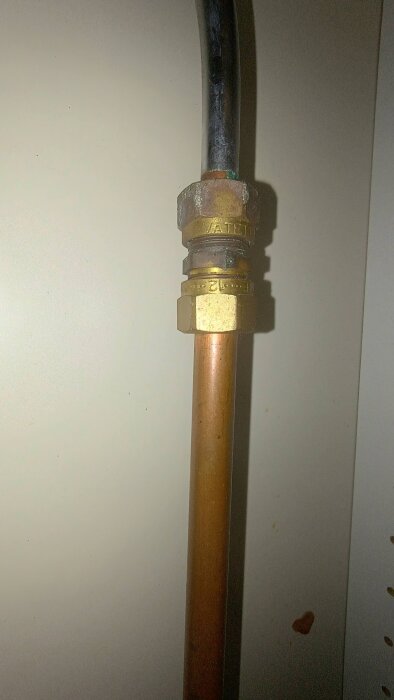 Gammal köksblandarkoppling i mässing med Vatette 12x10 klämringskoppling, ansluten till ett kopparrör.