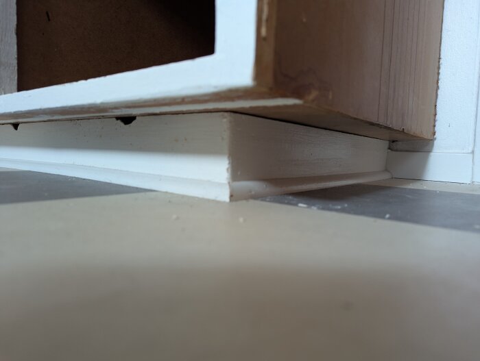 Köksskåp med stort överhäng på golvsockel i samband med installation av diskmaskin under köksrenovering.