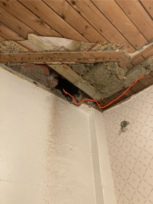 Bild på tak med murstock och träpanel, där ett rött streck visar planerad placering av spirorör för frånluftsventilation.