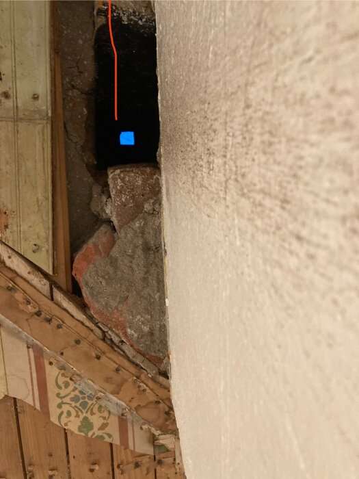 Öppning i taket med stenar och röd linje visar planerad plats för spirorör. Blått ljus syns längre in i öppningen.