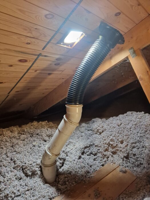 Flexrör genom tak med isolering, sett från vinden. Monterat i nytt hål med gummikrage och metallkrage för ventilation.