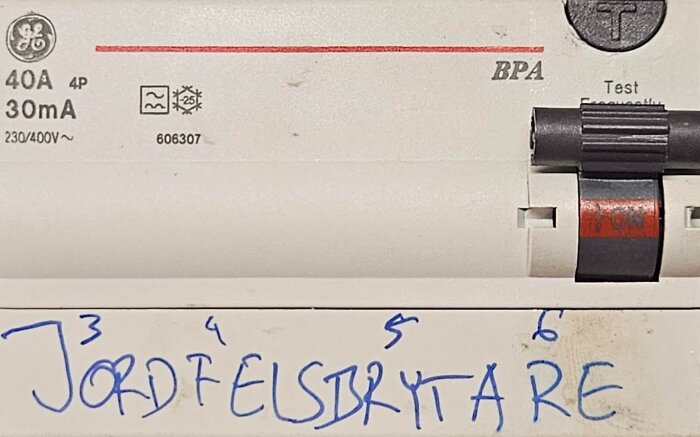 Jordfelsbrytare med märkning 40A 30mA, handskriven text under, visar elektrisk komponent.