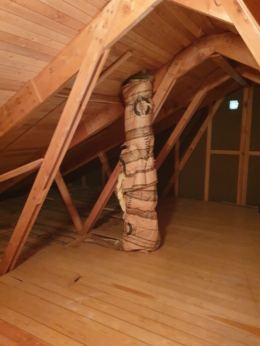 Vind med trägolv och bjälkar samt ett isolerat rör i mitten.