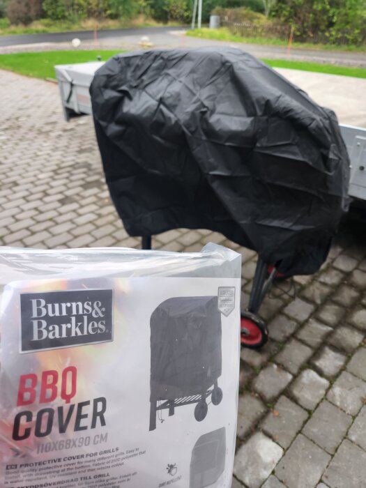 Överdrag till en betongblandare syns på en bild med en förpackning märkt "Burns & Barkles BBQ Cover" i förgrunden.