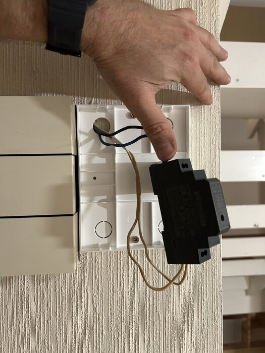 Hand monterar en Aqara G4 ringklockas transformator på en vägg, visar kablar och dosa för anslutning.